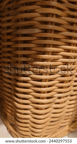 A closeup of the texture and weave in an old, woven basket, highlighting its natural beauty. The background is neutral to highlight details. Soft lighting creates gentle shadows on wicker pattern.