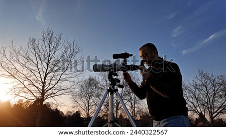 Amateur astronomer observing Sun eclipse and Sun with a telescope and special solar filter. Royalty-Free Stock Photo #2440322567