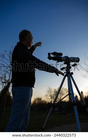 Amateur astronomer observing Sun eclipse and Sun with a telescope and special solar filter. Royalty-Free Stock Photo #2440322573