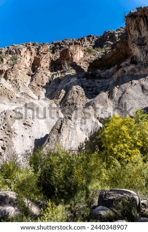Bandelier National Monument in New Mexico. Hot ash from volcano at Valles Caldera cooled and welded into rock called tuff. Pajarito Plateau and Frijoles Canyon show Volcanic Geology. Pueblo Loop Trail Royalty-Free Stock Photo #2440348907