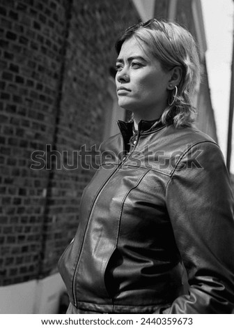 Analog side view portrait of woman posing in the street. Film analog camera, medium format. She is looking serious and confident.