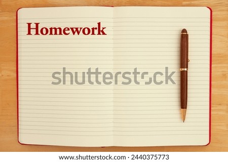  Homework message on lined rule paper notebook with a pen Royalty-Free Stock Photo #2440375773