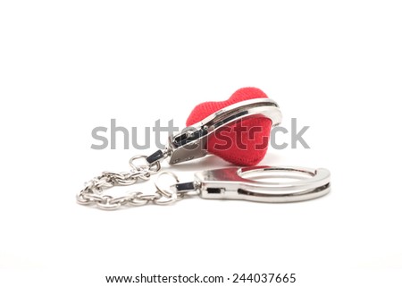 Close up of isolated red heart shape being locked by handcuffs, symbol of love and commitment for special event and valentine's day