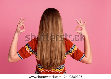 Rear behind photo of young girl hands fingers demonstrate okey symbol approval isolated on pink color background