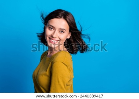 Photo of pretty adorable woman wear shirt wind blowing smiling empty space isolated blue color background