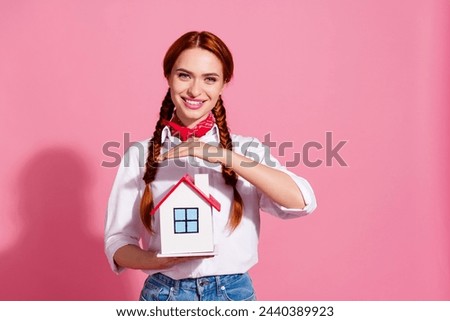Photo of adorable lovely girl realtor wear trendy clothes hold miniature house dream own new flat isolated on pink color background
