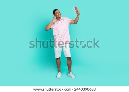 Full size photo of cool guy dressed casual polo white shorts make selfie on smartphone show thumb up isolated on teal color background