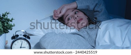 Anxiety disorder on insomnia woman concept, sleepless Woman open eye awakening on the bed at night time can't sleep from symptom of depression diseased. Royalty-Free Stock Photo #2440425519