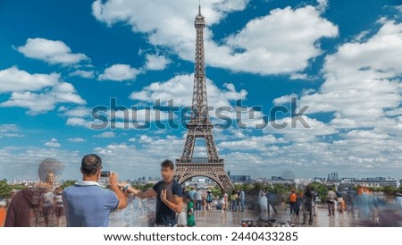 People walking on famous square Trocadero with Eiffel tower in the background timelapse. Trocadero and Eiffel tower are the most visited attractions of Paris. Blue cloudy sky at summer day