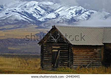 Detail of cabin with elk rack and mountains in the background