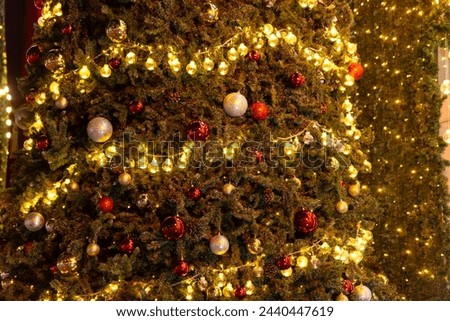 Beautiful Christmas ornament hung on lit tree