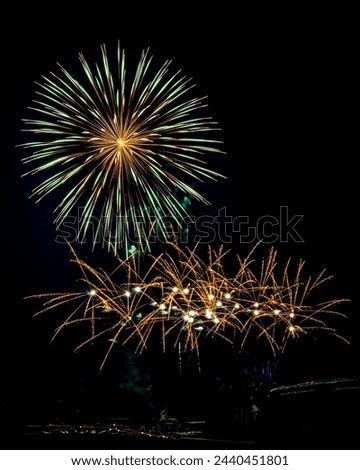 Explosions of vibrant colors light up night sky at a Fireworks Display during a 4th of July celebration.