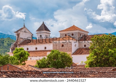 Historic church in Santa Fe de Antioquia, Colombia, showcasing colonial architecture against a scenic backdrop of mountains and sky