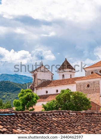 Historic church in Santa Fe de Antioquia, Colombia, showcasing colonial architecture against a scenic backdrop of lush mountains and blue sky