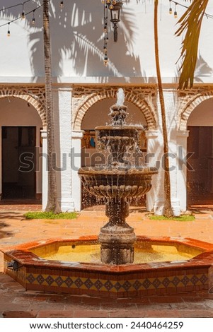 Charming courtyard in Santa Fe de Antioquia, Colombia, featuring a classic fountain, colonial architecture, and festive string lights