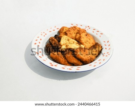 Picture of fried chicken, egg, chicken nuggets, Bakwan Jagung and fried beef. Bakwan Jagung is Indonesian food made from corn mix with flower and some seasoning. Picture of fried food 