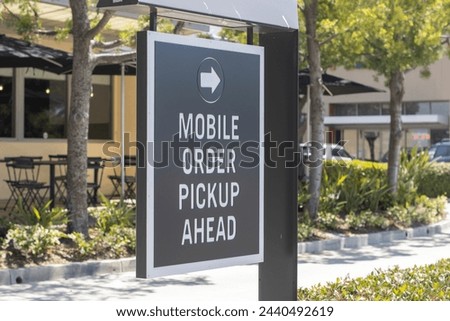 Mobile Order Pickup Ahead directional signage outside a fast food restaurant.