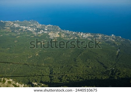 View from Ay petri mountain towards the crimean sea, with visible cable car lines leading to the lower station. Royalty-Free Stock Photo #2440510675