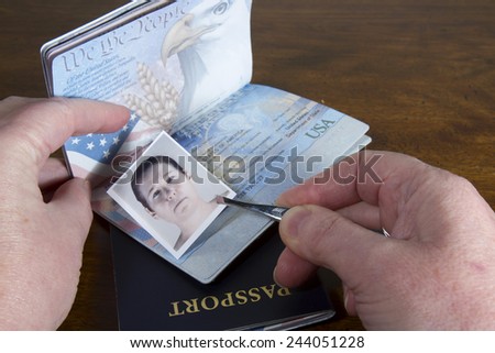 Hand with tweezers holding id photo over passport as if forging the travel documents Royalty-Free Stock Photo #244051228