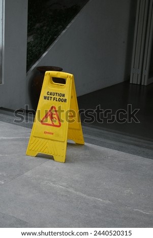 yellow signs that say "caution wet floor" in front of the building entrance