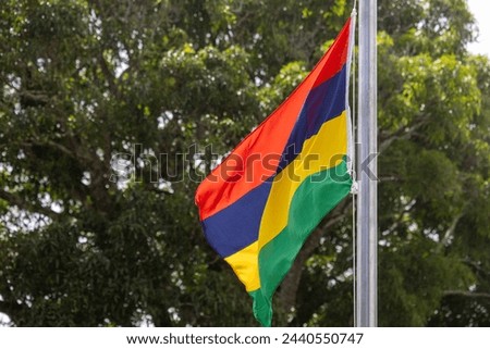 The national flag of Mauritius flutters on the lawn