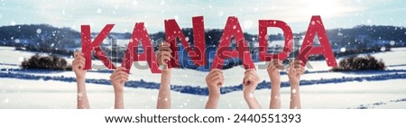 People Or Persons Hands Building German Word Kanada Means Canada. White Winter Background With Snowflakes And Snowy Landscape.