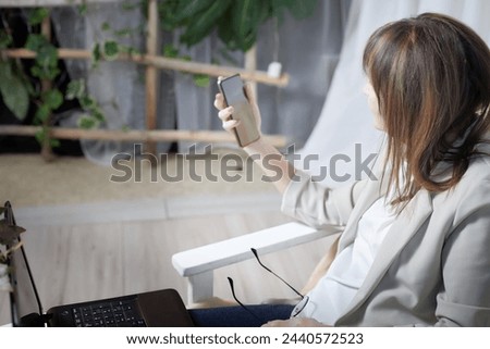 An elderly senior woman with a cell phone takes a selfie. A lady blogger is chatting online. Technologies for pensioners