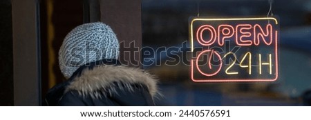 "Open 24 hours" sign on the store, child enters the store