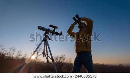 Amateur astronomer observing skies with binoculars and telescope. Royalty-Free Stock Photo #2440585173