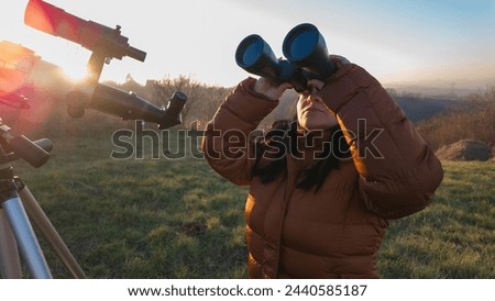 Amateur astronomer observing skies with binoculars and telescope. Royalty-Free Stock Photo #2440585187