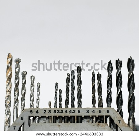 Photo of various sized and shaped steel drill bits set,white background with numbers showing sizes, in the studio photography style, macro shot from the side, with soft lighting, high resolution.