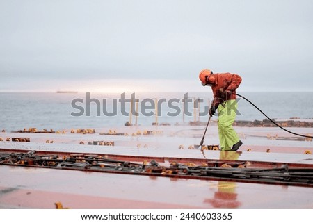 Seaman Seafarer In Safety Clothes Working On Deck Hatch Holding  Royalty-Free Stock Photo #2440603365