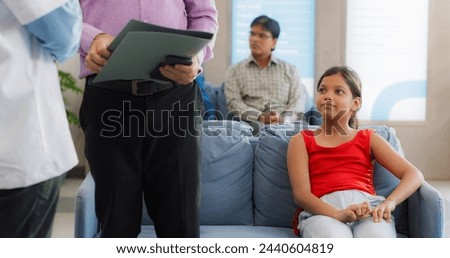 Portrait of Little Indian Girl Going to the Hospital with her Father for Health Check Up: Worried Girl Feeling Relieved after Hearing Good News from her Family Doctor in a Clinic Royalty-Free Stock Photo #2440604819