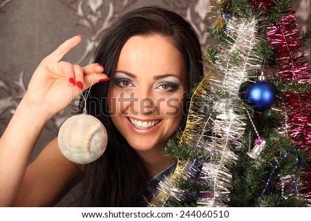 winter, holidays, happiness and people concept - smiling woman in santa helper hat over living room with christmas tree background, studio