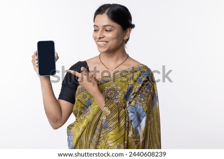 Portrait of woman advertising pointing on blank mobile phone screen
