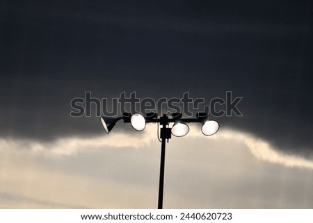 Dark clouds over stadium lights at a baseball field Royalty-Free Stock Photo #2440620723