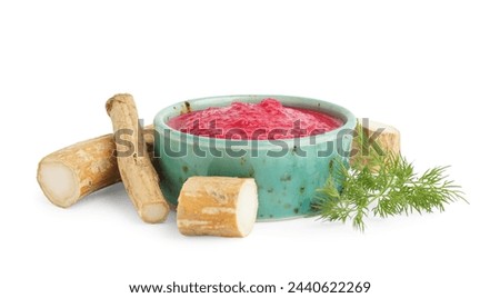Horseradish sauce with beet in bowl and greens on white background