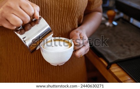 Barista pouring milk into coffee making a cappuccino. Barista making cappuccino,Professional bartender preparing coffee drink