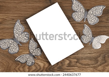 Wedding invitation card mockup decorated with butterflies on wood table. Blank card mockup