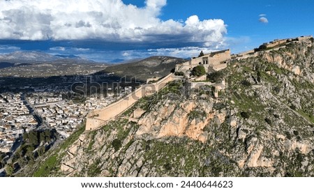 Aerial drone photo of beautiful landmark castle of Palamidi built uphill overlooking iconic city of Nafplio in a nice spring morning with white clouds and deep blue sky, Argolida, Peloponnese, Greece