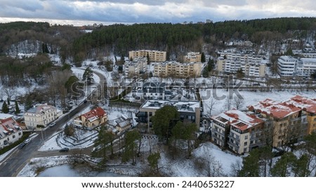 Drone photography of small multistory houses near a forest in a city during winter cloudy day