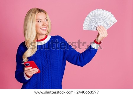 Photo of pretty lady hold phone dollar bills wear blue sweater isolated on pink color background