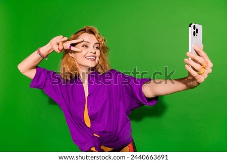 Photo portrait of pretty young girl take selfie show v-sign posing wear trendy purple outfit isolated on green color background
