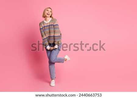 Full length photo of girlish adorable girl dressed print sweater jeans trousers look at logo empty space isolated on pink color background