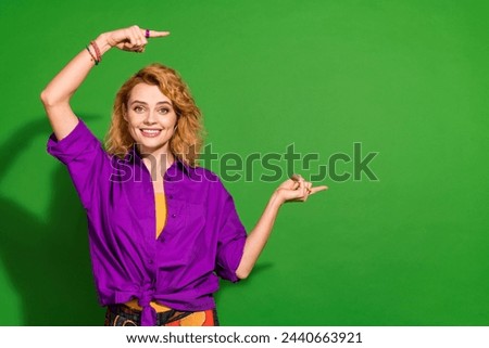Photo portrait of pretty young girl point empty space poster wear trendy purple outfit isolated on green color background