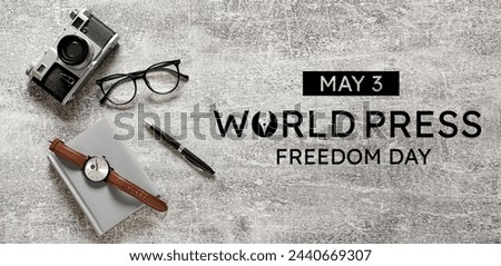 Notebook, eyeglasses, pen, watch and photo camera on grunge background. Banner for World Press Freedom Day 
