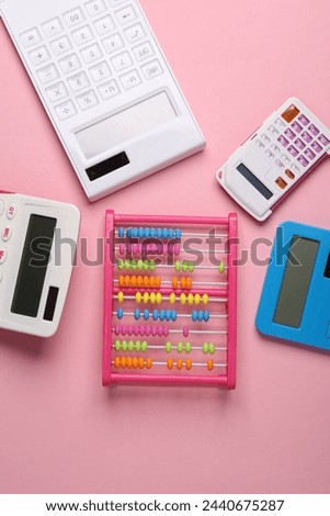 Many different calculators and abacus on a pink background