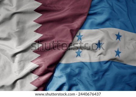 big waving national colorful flag of honduras and national flag of qatar. macro