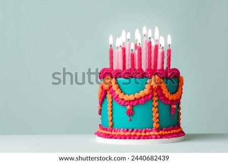 Elaborate jade colored birthday cake with pink and orange piped vintage style frills and birthday candles Royalty-Free Stock Photo #2440682439