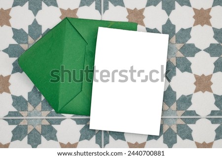Wedding invitation card mockup and green envelope on seamless floral Algerian background. Blank card mockup